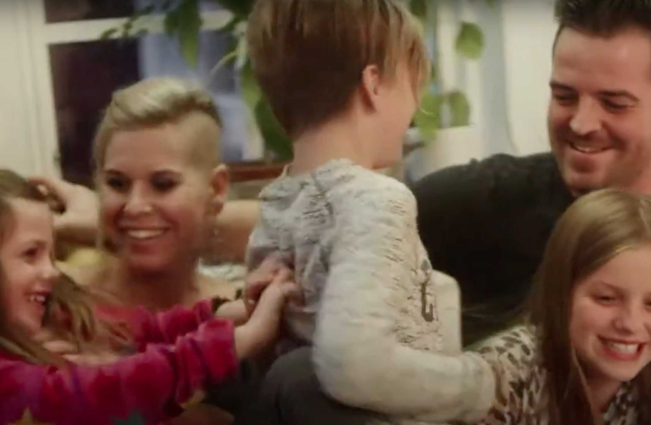 Familj busar i soffan i pelletsvärmt hus